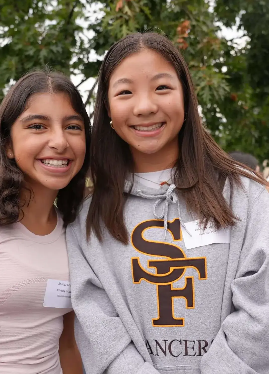 Saint Francis students wearing L:ancer gear smiling at the photographer during an event.