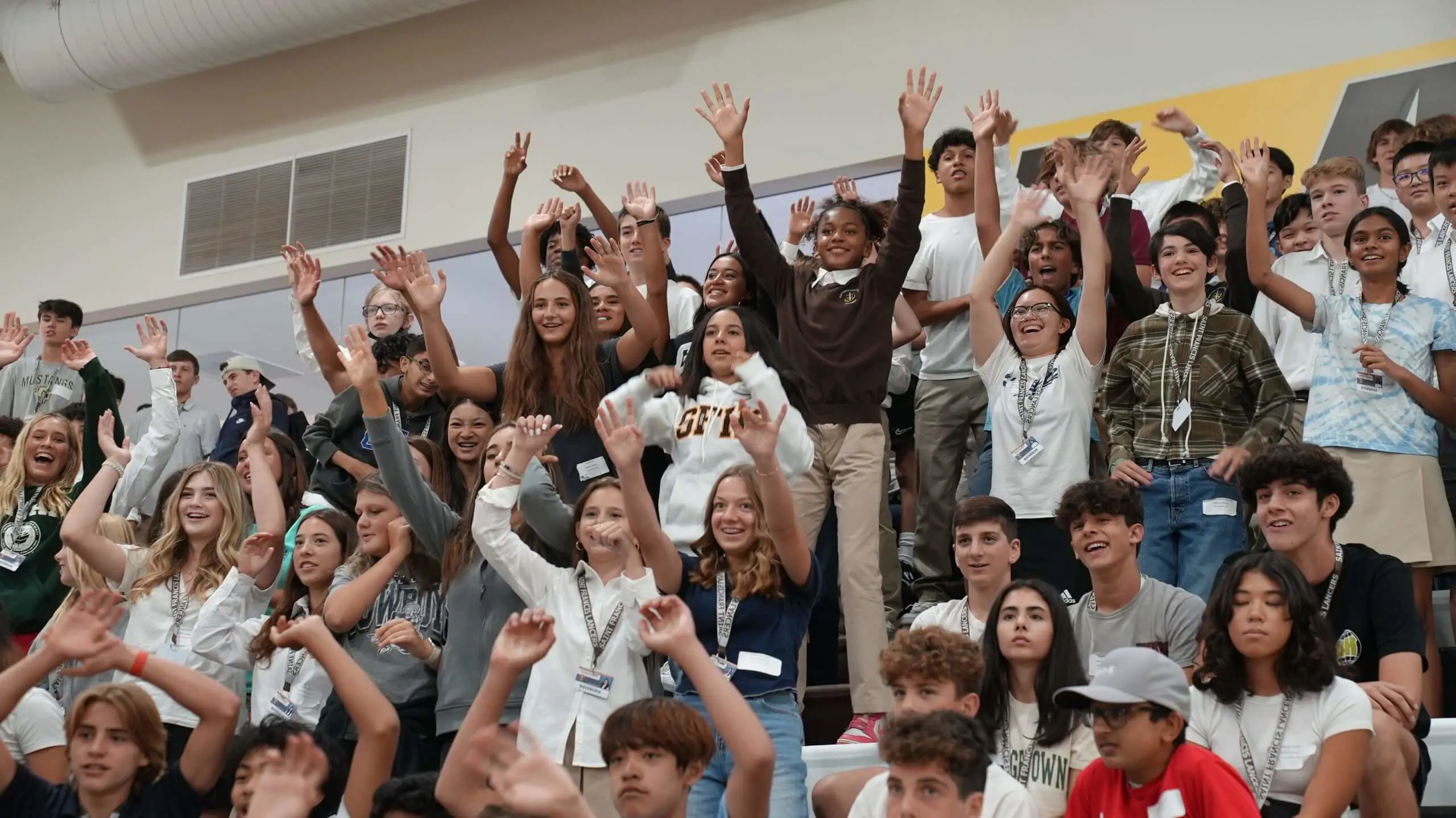 A group of students cheering on the Burns gym stands.