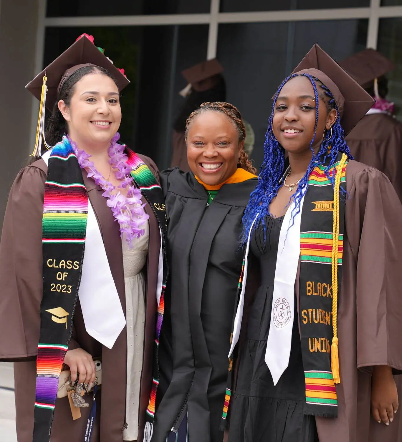 Students from Black Student Union posing in graduation gowns with their moderator.