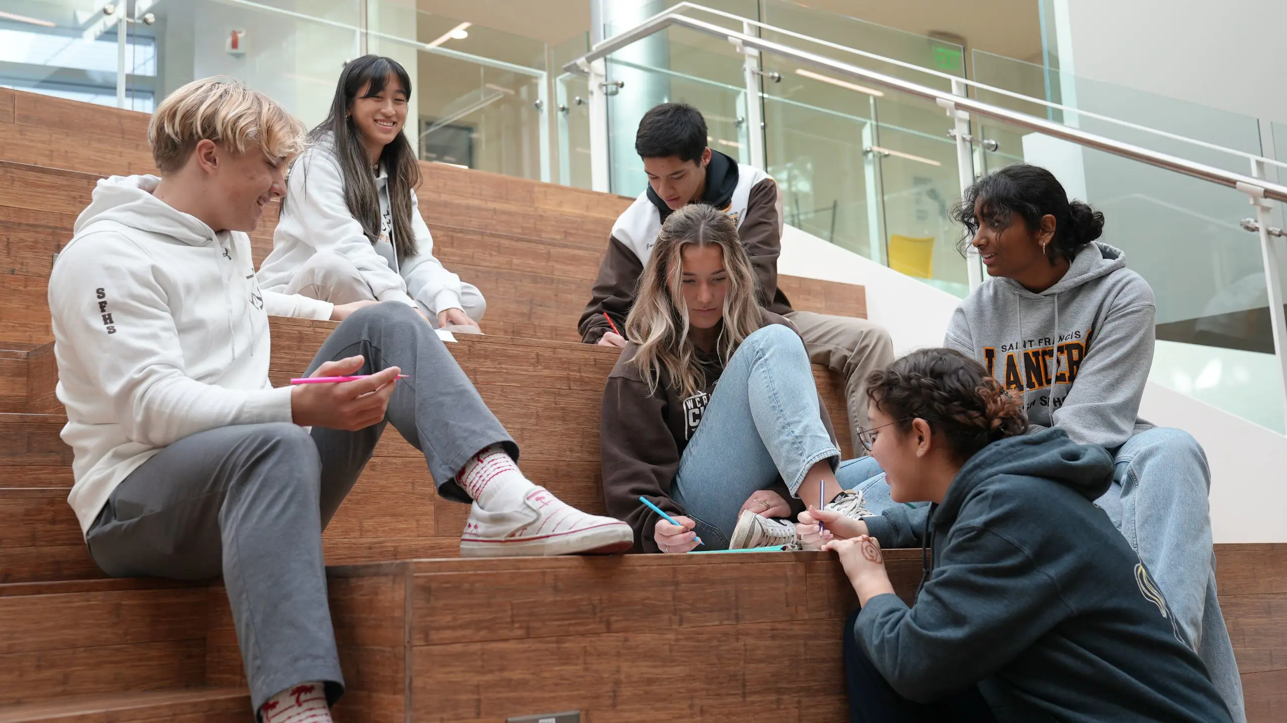 Students cheerfully interacting with one another on the Welcome Stairs.