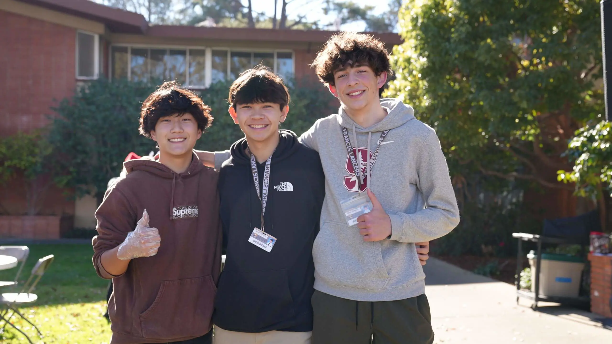 Students pose each giving a thumbs up with cheerful expressions.