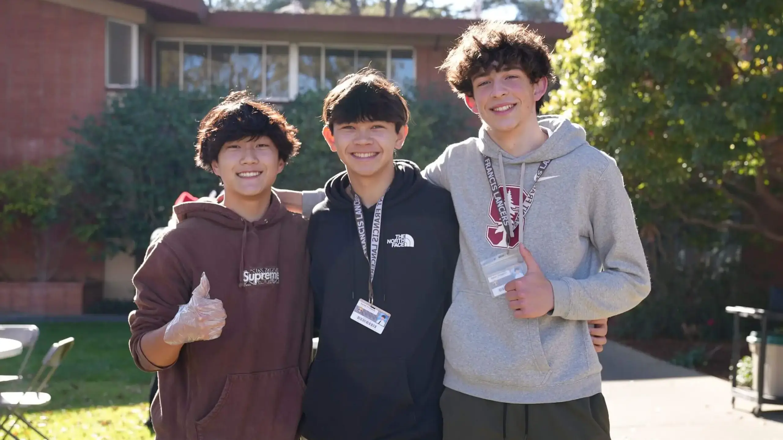 Students pose each giving a thumbs up with cheerful expressions.