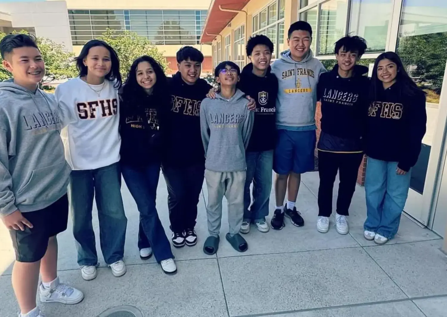 Student standing shoulder to shoulder smiling for a photograph.