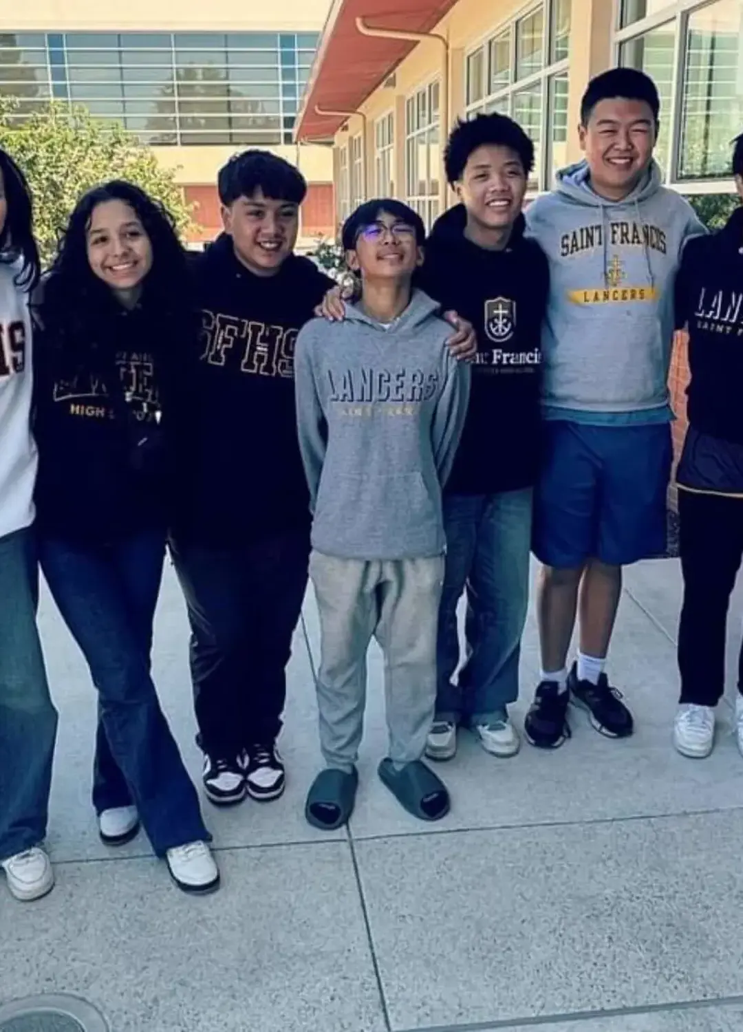 Student standing shoulder to shoulder smiling for a photograph.