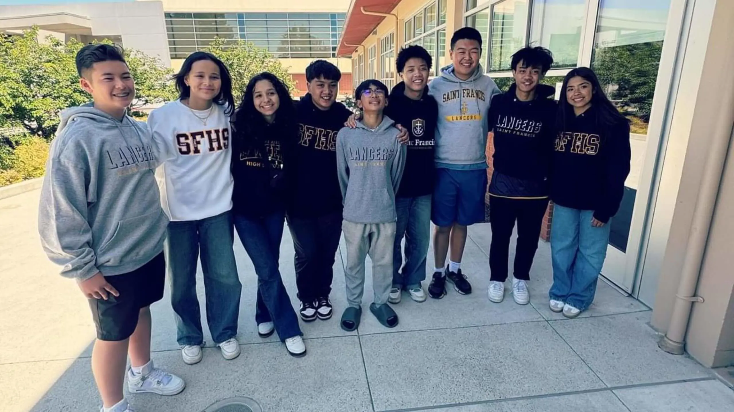 Students standing shoulder to shoulder and smiling for a photograph.