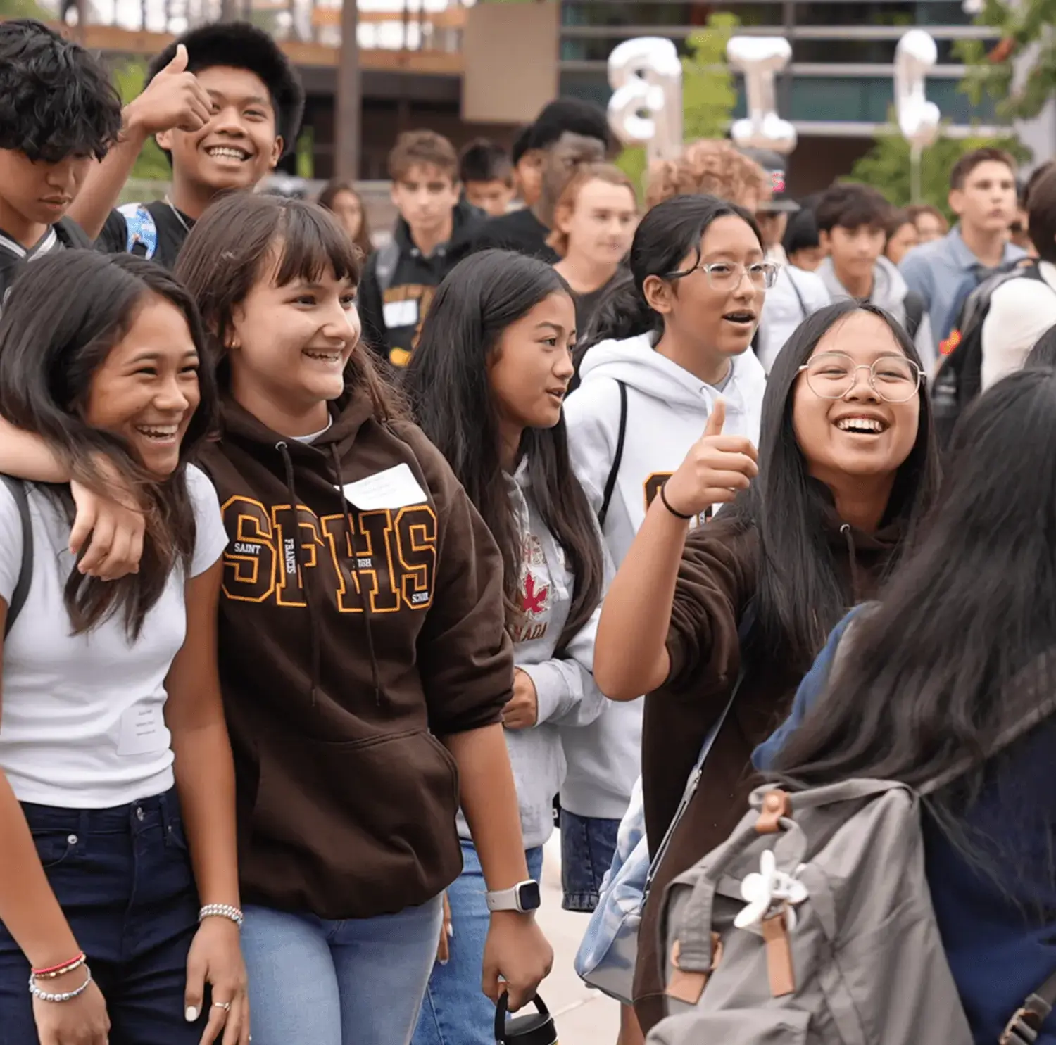 A lively group of young friends laughing and smiling, showcasing their joy and camaraderie.