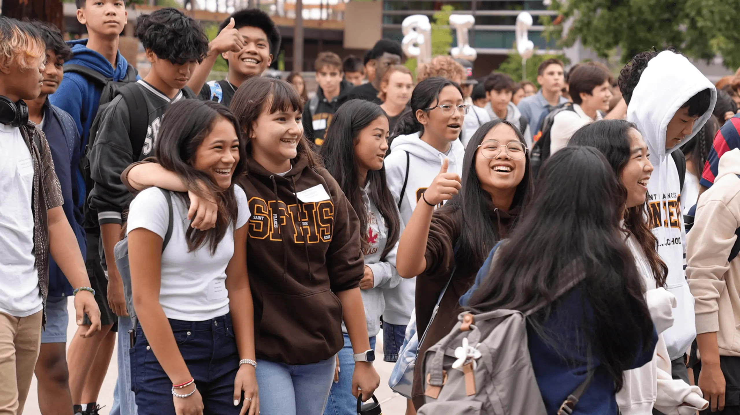 A lively group of young friends laughing and smiling, showcasing their joy and camaraderie.