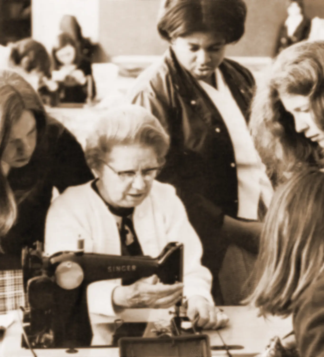 Students at Holy Cross High School being instructed on how to sew.