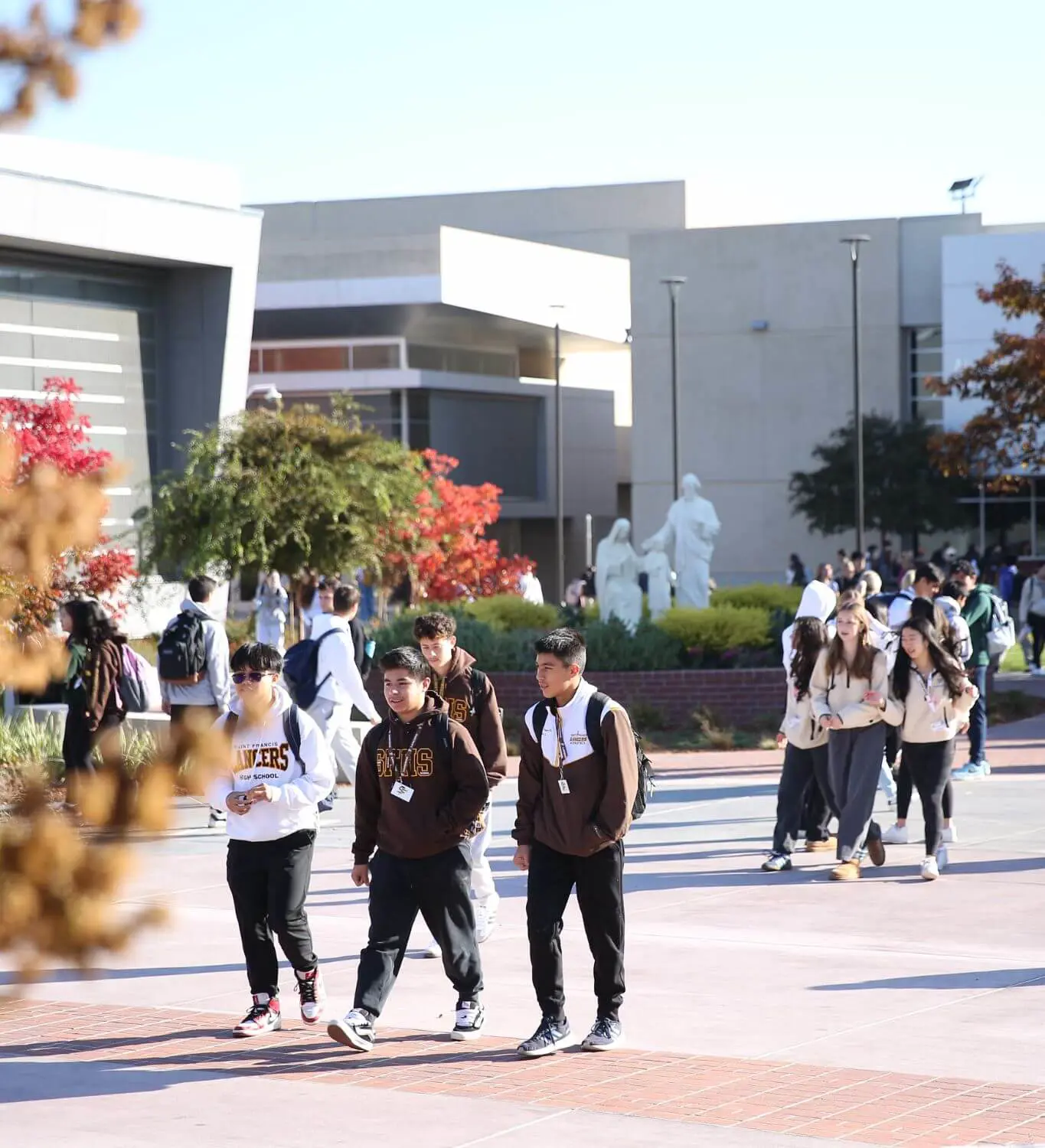 Groups of student traversing through the new quad between classes.