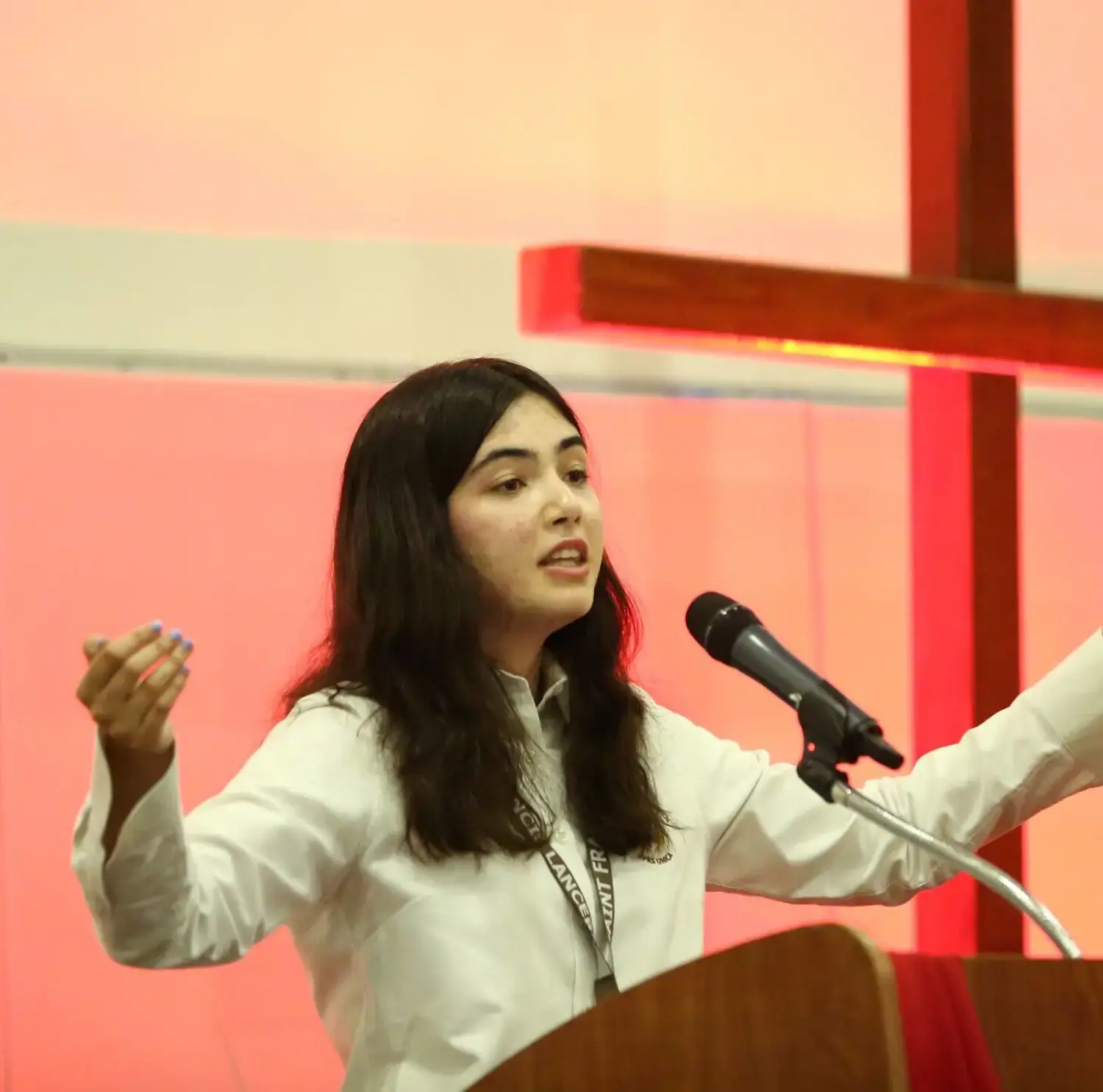 A Student standing at the ambo leading the student body in prayer.