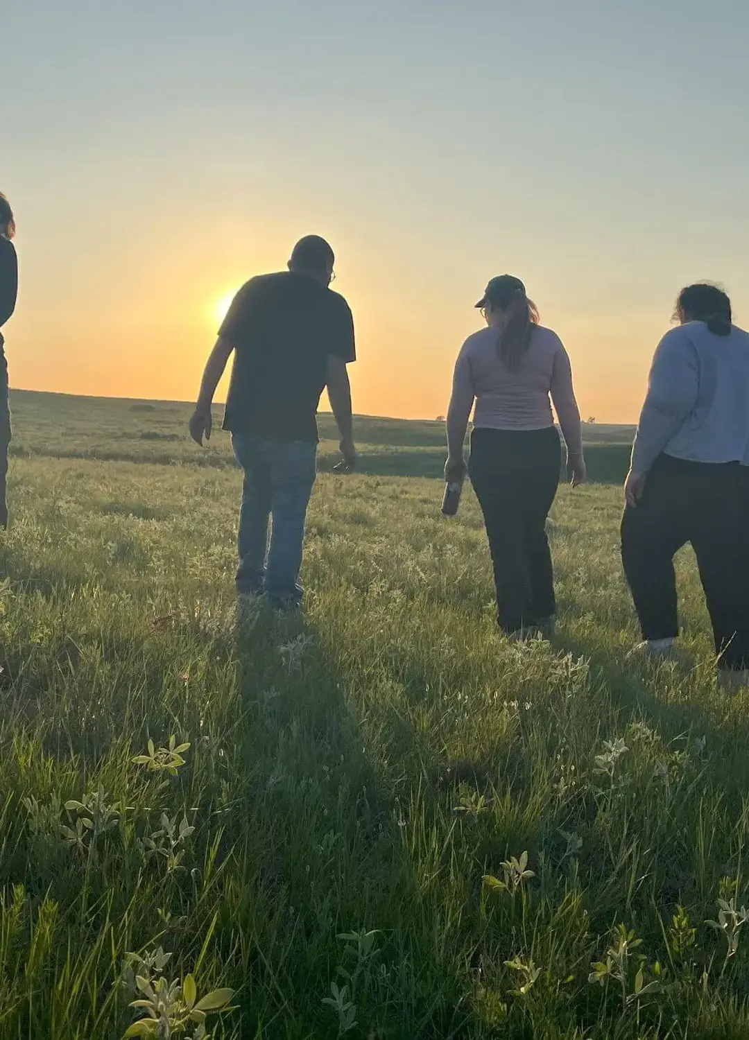 Students on immersion walking on a South Dakota prairie while serving on tribal lands.