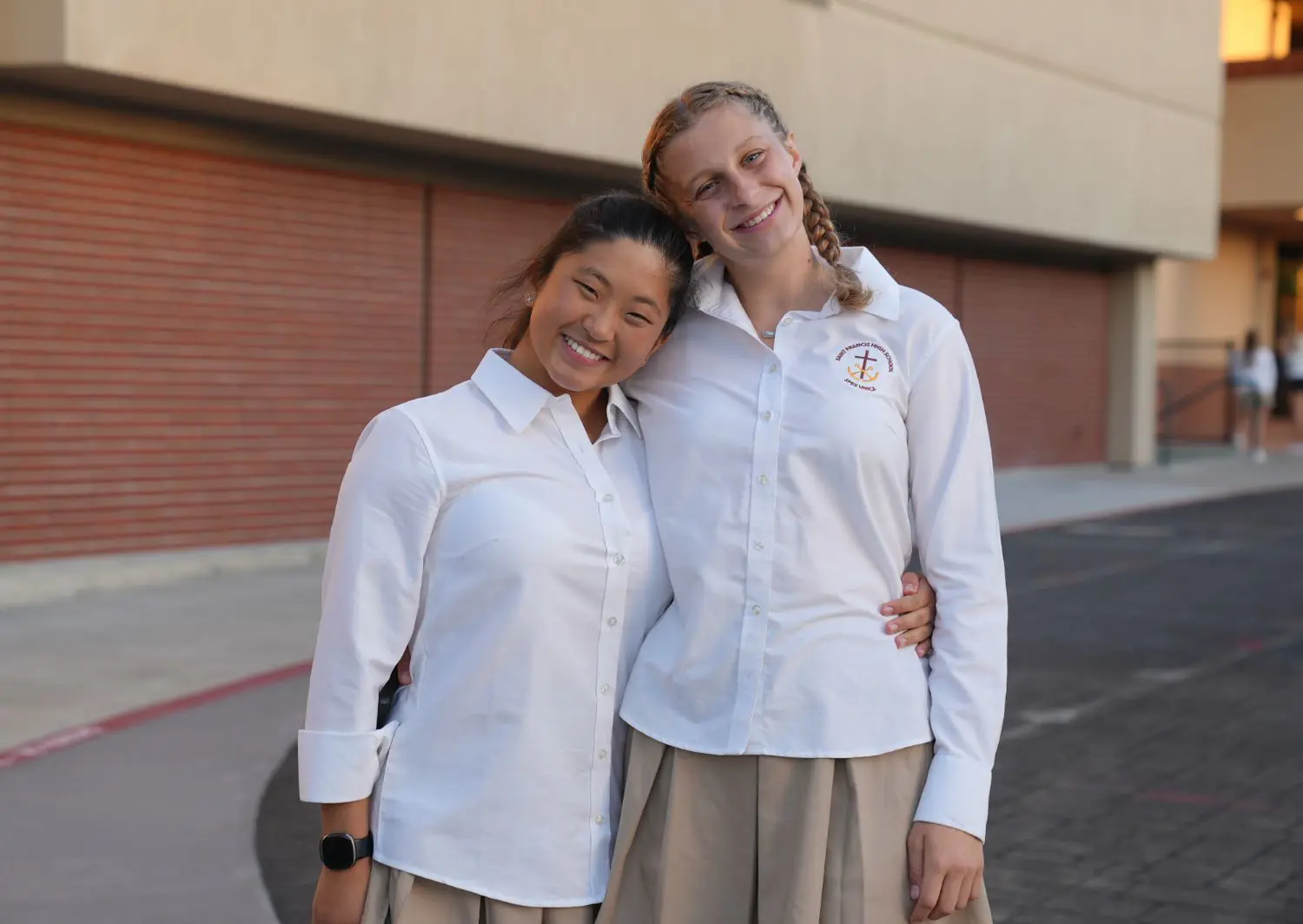Students happily embracing with arms around each other’s back.