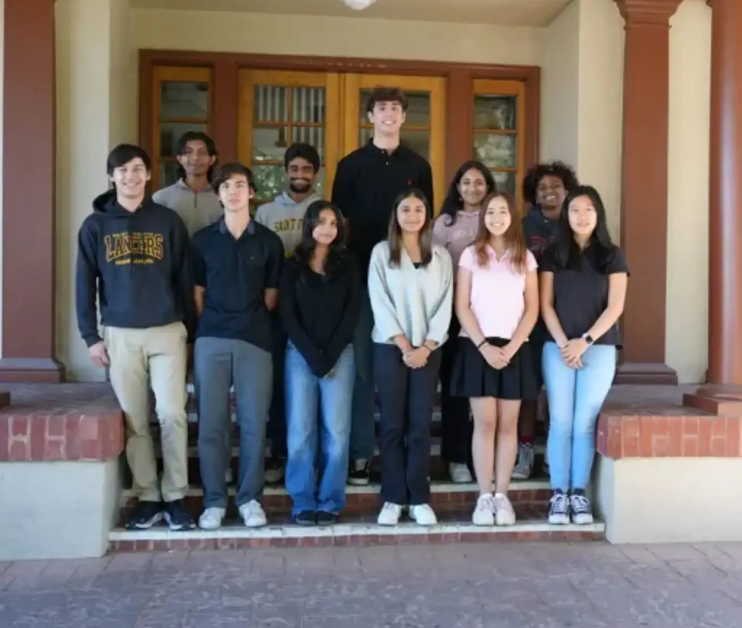 11 Lancers Named National Merit Scholarship Semifinalists posing together for photograph on steps.