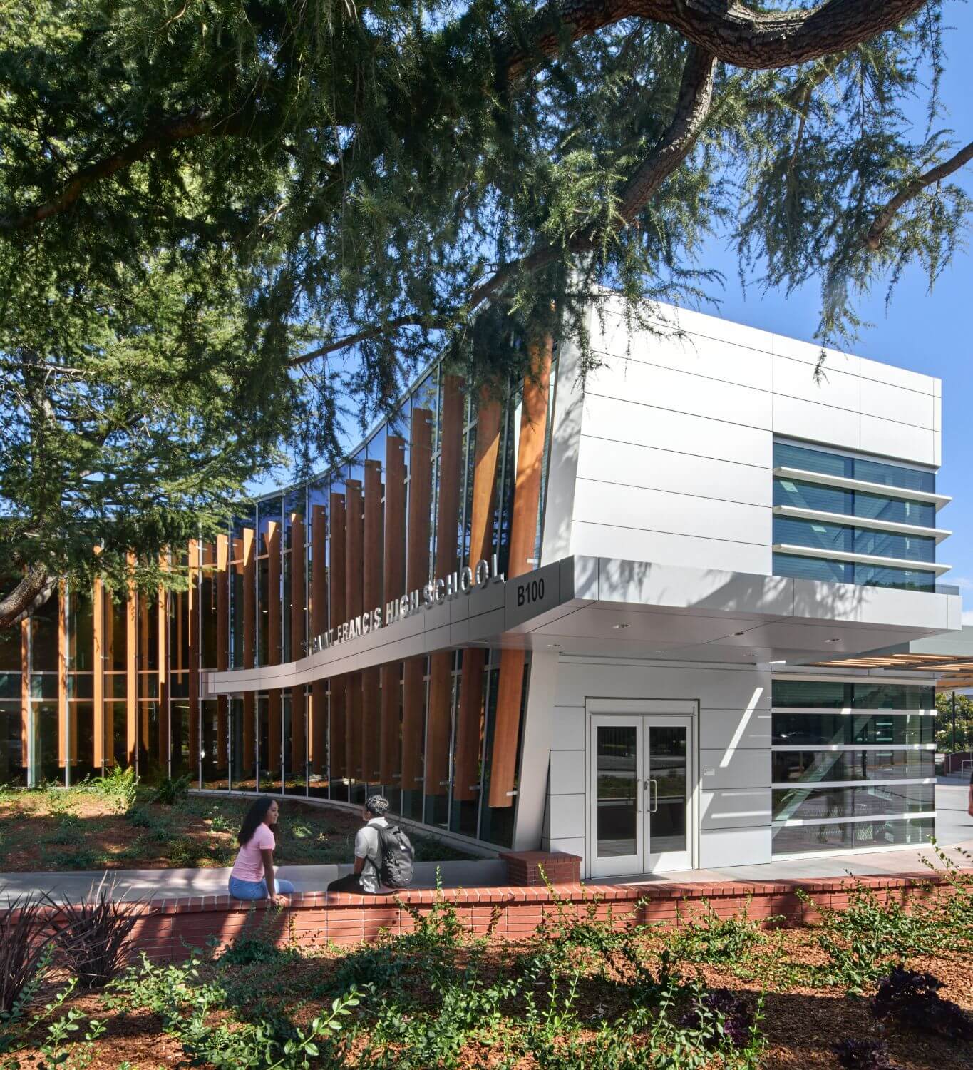 Exterior shot of front doors of the Welcome Center with students walking through campus.