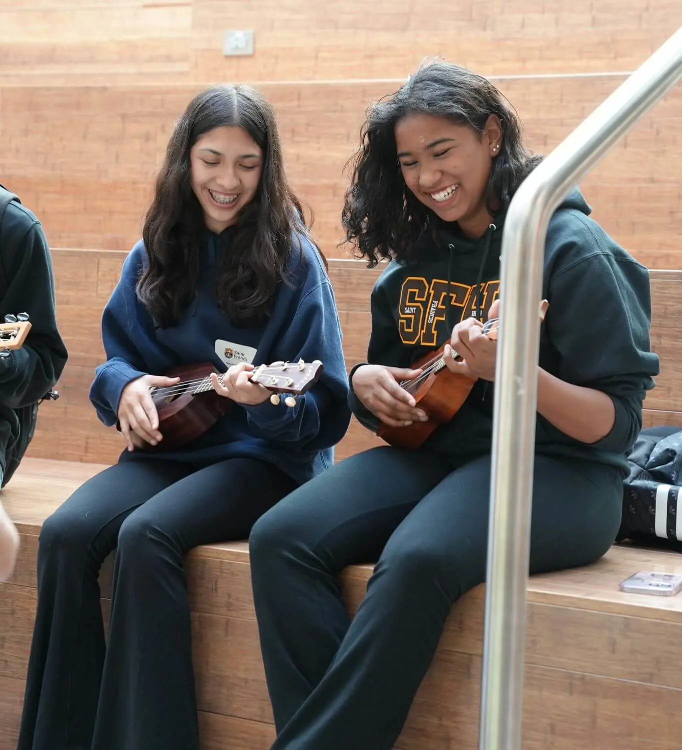 Students sitting on the Welcome Stairs playing Ukulele together.