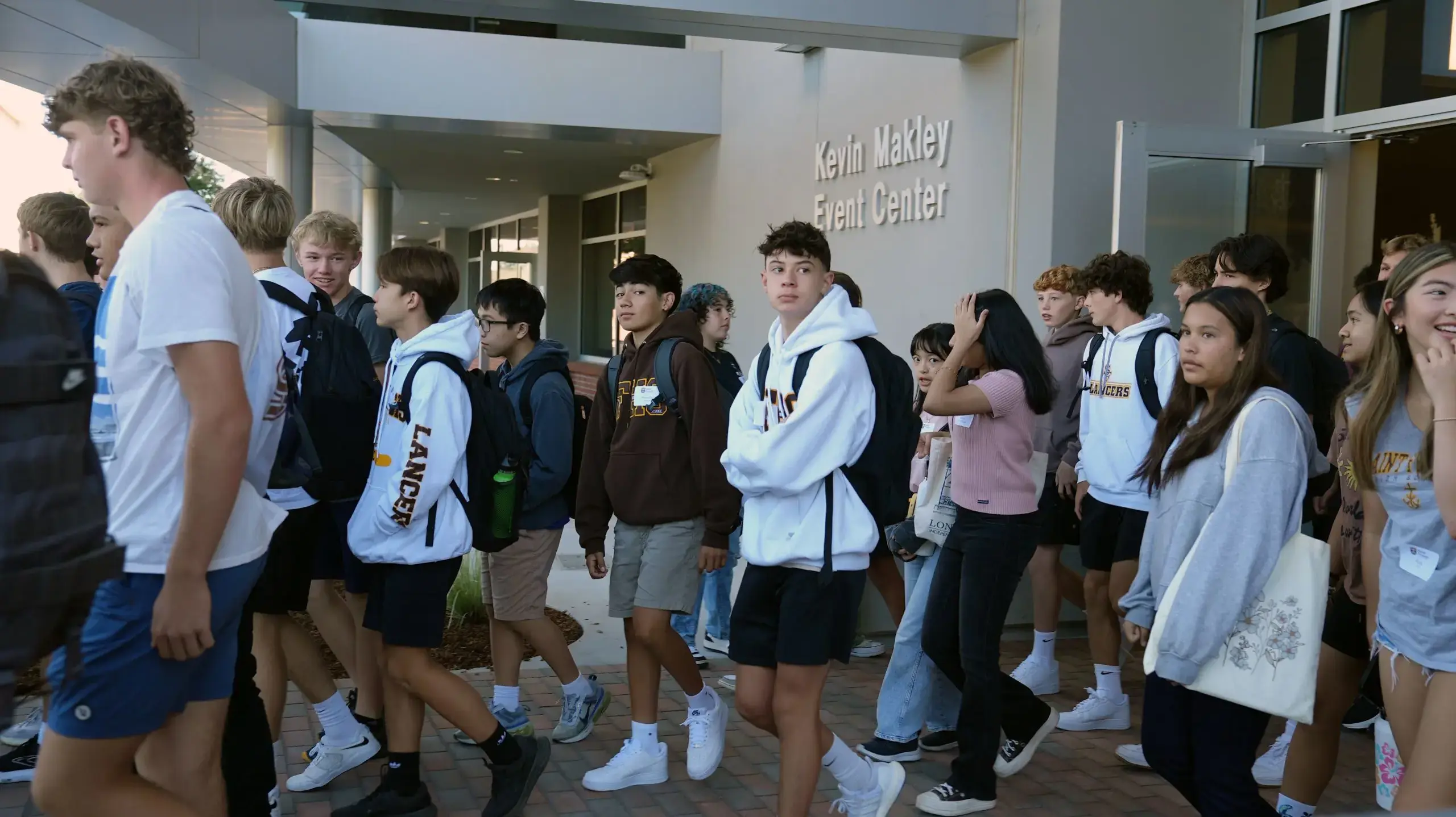 A class passes out of the Makely Center main entrance in a large group.