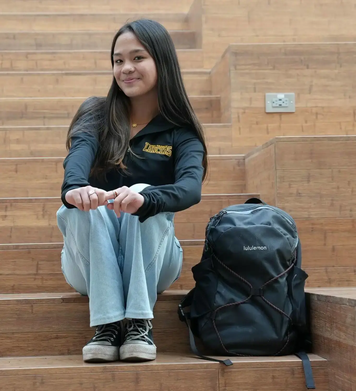Ava Grace Sanchez sitting on the Welcome Stairs in the Eggers Innovation Center.