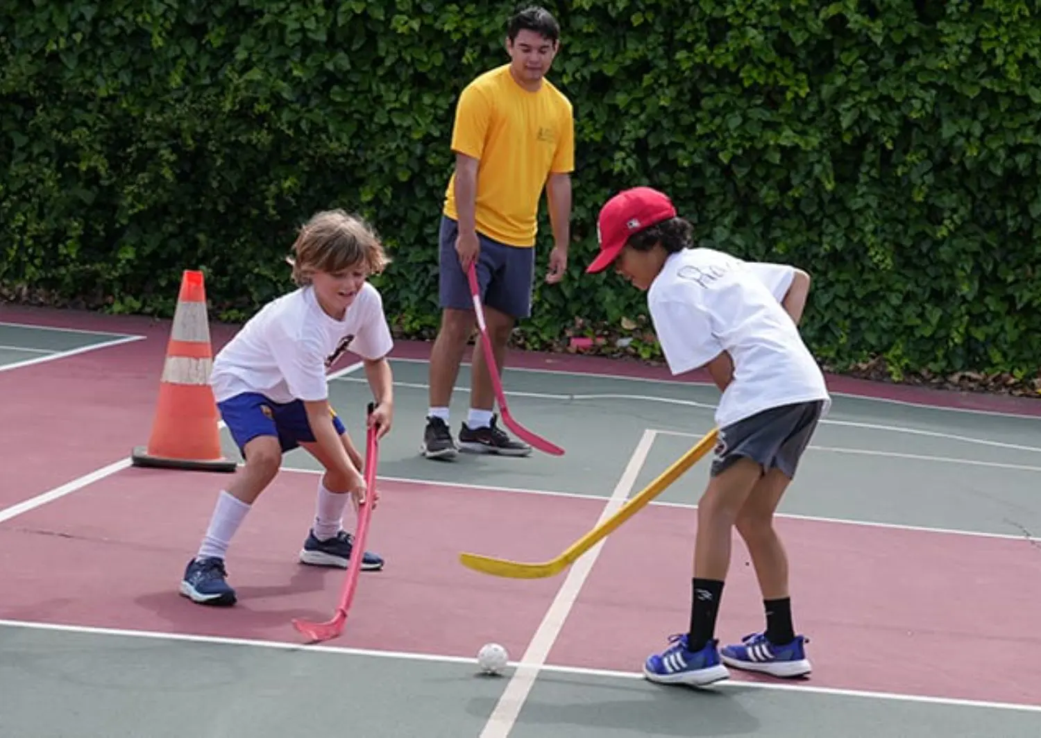Campers playing street hockey.