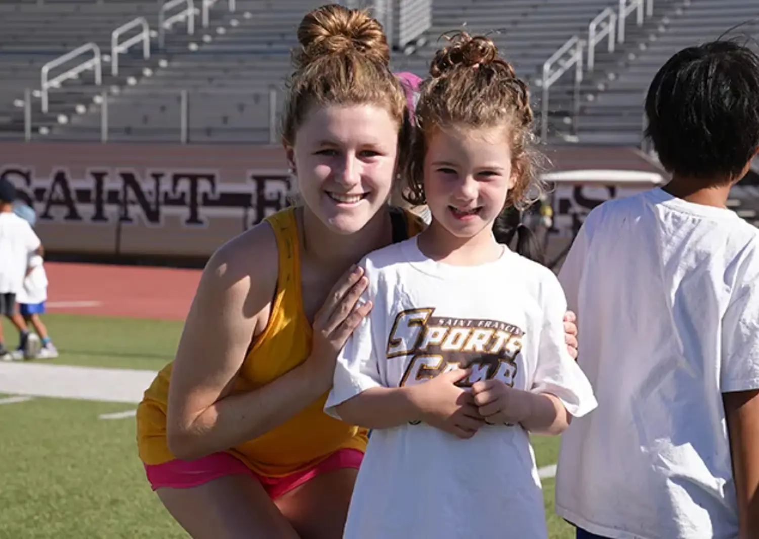 Happy camper smiling and posing with a counselor.