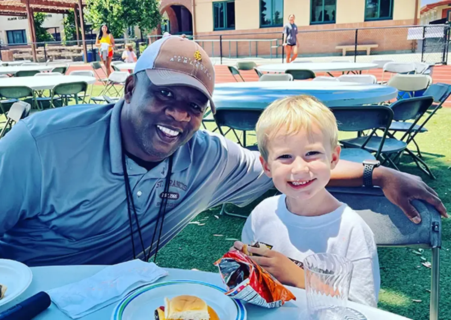Counselor having lunch with a camper.