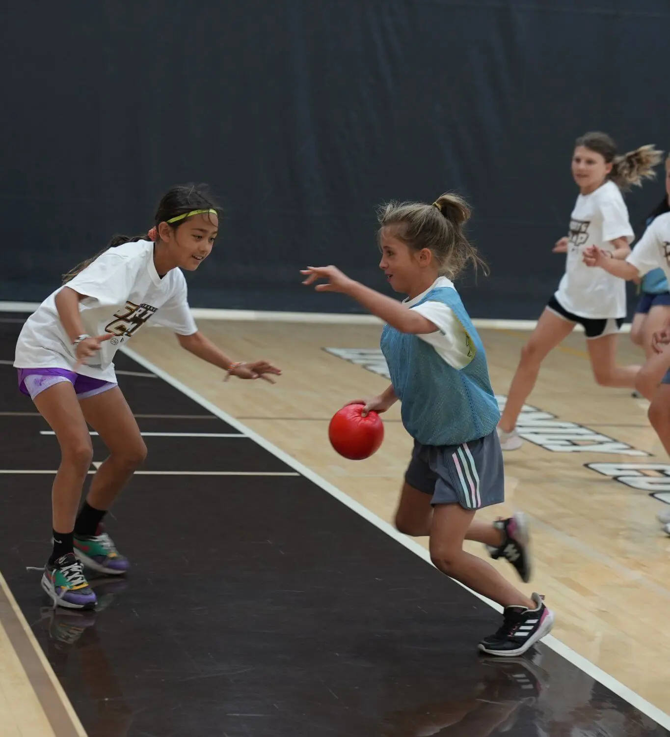 One camper defending while a second camper advances while playing handball.
