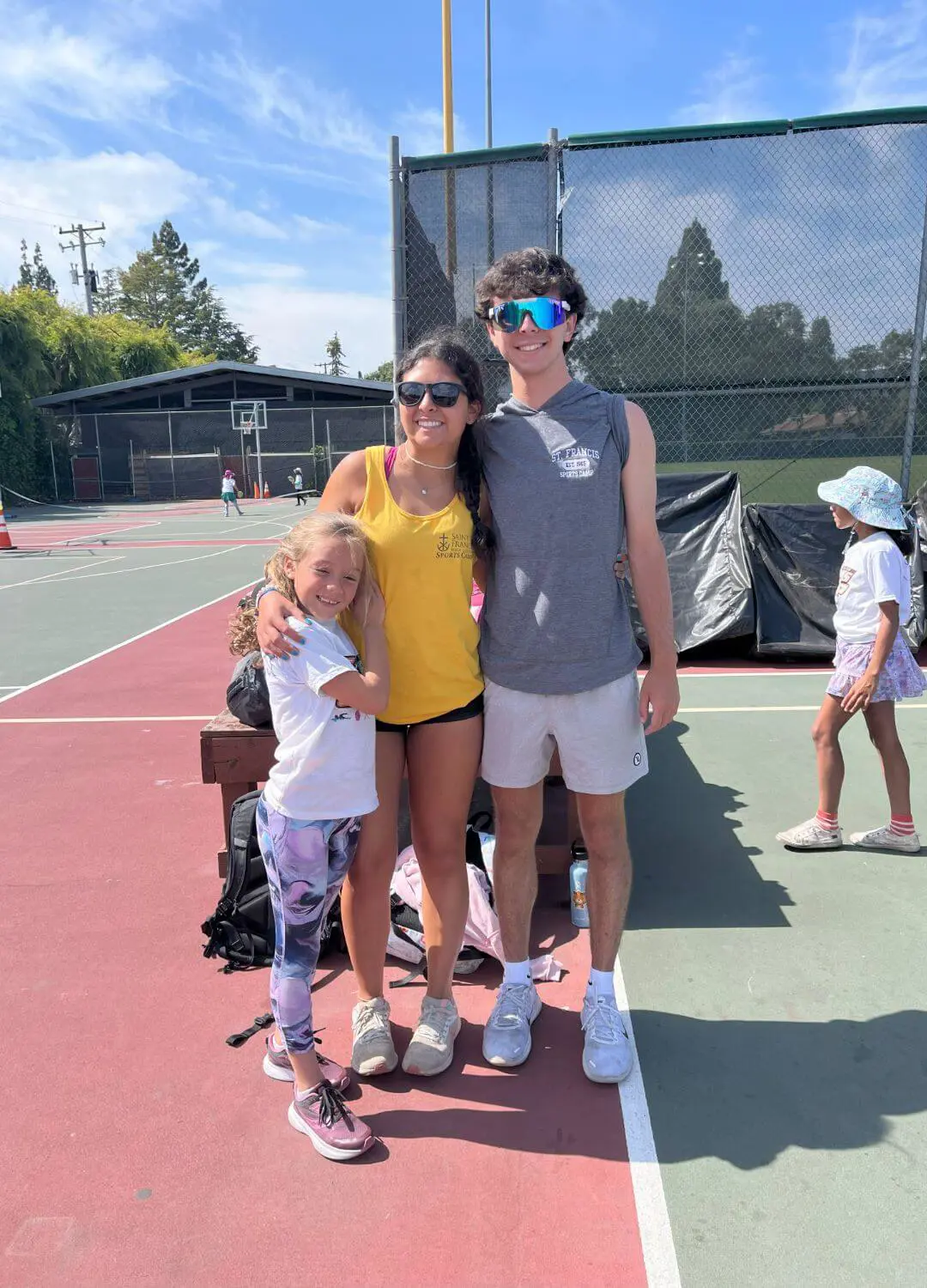 Two counselors and a camper posing with smiles.